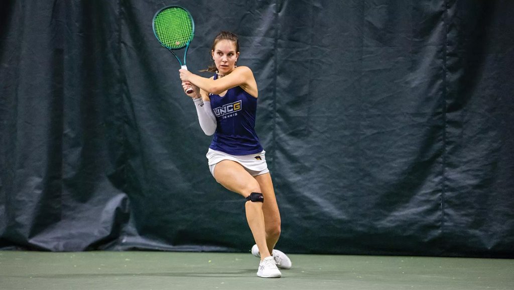 Alexandra Dodashev holds her tennis racket on the court while playing for UNCG.
